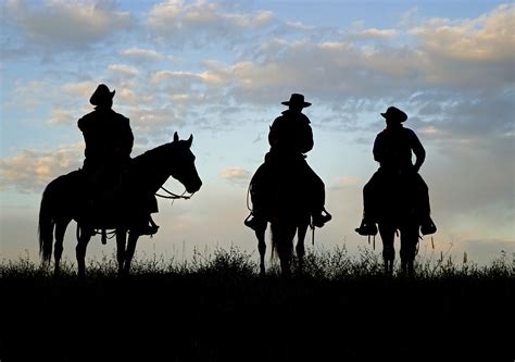 A cowboy is sitting on a horse in the sunset swinging a rope with the silhouette of a cowgirl standing off to his side holding on cowboy on a horse. Chatting with Anna Kathryn: Saturday's Salacious ...