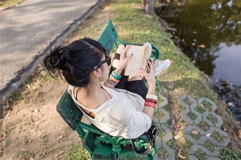 Woman Sitting On A Park Bench Enjoying A Book By Stocksy Contributor Jovo Jovanovic Park