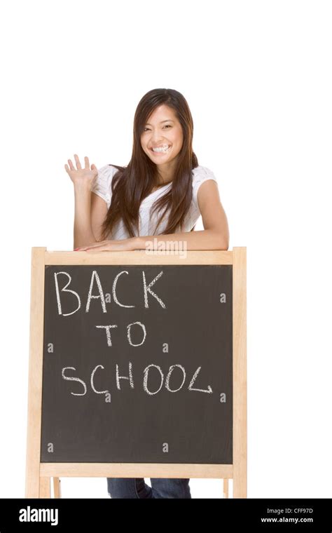 Friendly Asian High School Girl Student Standing In Jeans By Blackboard