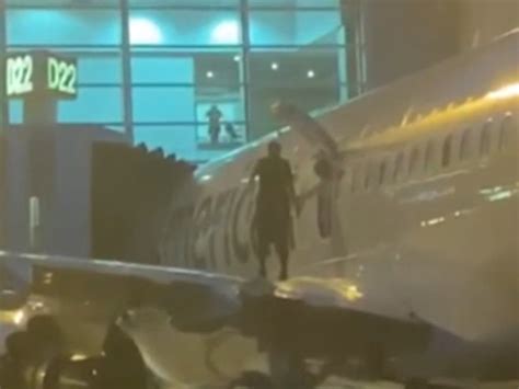 Passenger Opens Emergency Exit Door And Walks Along Plane Wing