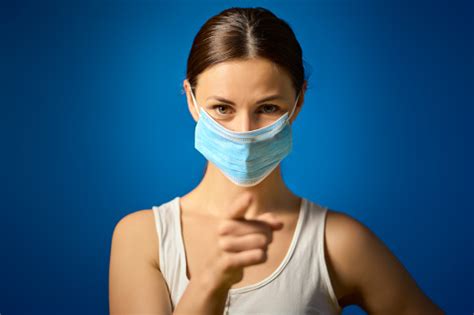 Woman In White Shirt Shows How To Wear A Mask During A Pandemic Stock