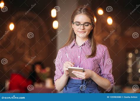 Portrait Of A Beautiful Friendly Waitress In Glasses With Notepapers