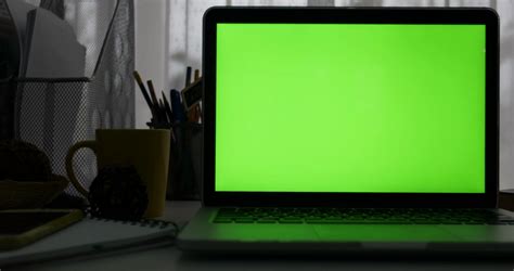 Laptop with green screen. Dark office. Perfect to put your own image or ...