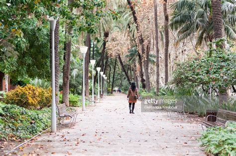 Young Woman Walking In Lush Green Tropical Gardens In Malaga Andalusia