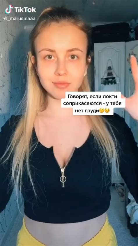 tiktok user marusinaaa squeezing her clothed boobs together with her arms showing her