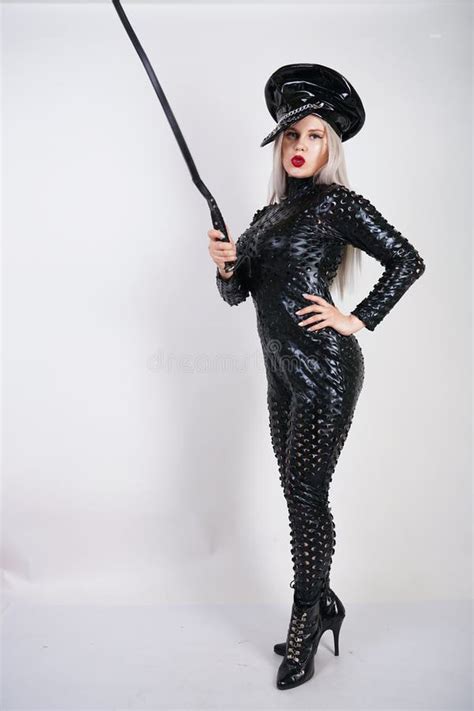 Cruel Fashionable Bdsm Lady With Curves Dressed In Black Catsuit With Holes And Posing On A