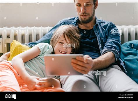 Padre E Hijo Viendo Una Película En Tablet En Casa Fotografía De Stock