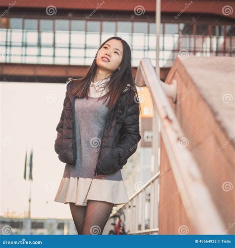 Het Jonge Mooie Chinese Meisje Stellen In De Stadsstraten Stock Foto