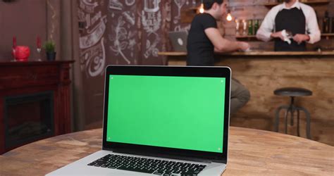 Maybe you would like to learn more about one of these? Laptop with green scree on a table in a vintage restaurant ...