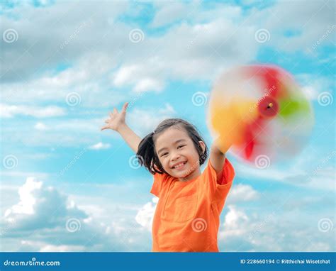 Children Playing Rainbow Pinwheel Or Windmill On Nature Happy Kids