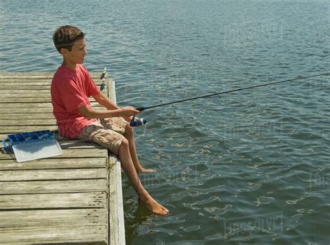 Boy Fishing Off Dock Stock Photo Dissolve