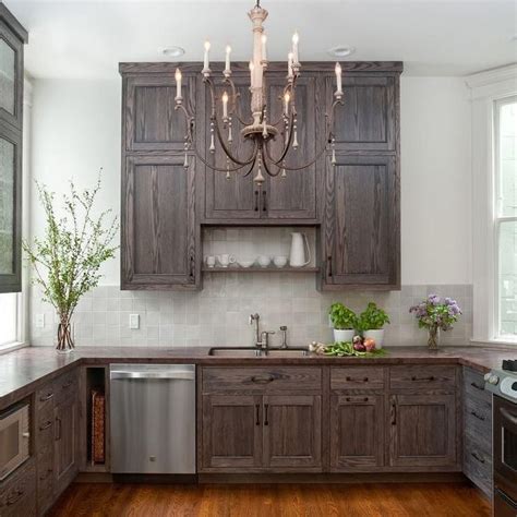 This oversized kitchen from indianakitchencompany not only features beautiful white painted kitchen cabinets, but the island sports a light gray stain that helps to give the space a little more depth and create a more rustic feel. Image result for red oak cabinets stained with grayish ...