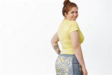 happy chubby woman in fitness clothes rear view redhead girl in workout outfit turn at camera