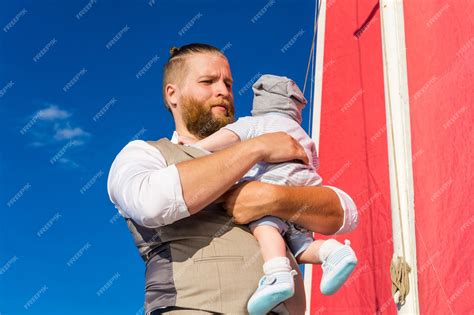 Premium Photo Bearded Man Holding A Baby In His Arms Against The