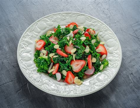 Healthy Kale Salad With Strawberries And Almond In A White Plate Stock
