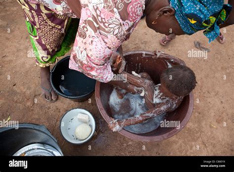 Une Mère Baigne Son Enfant Dans Un Bidonville De Bamako Mali Photo Stock Alamy