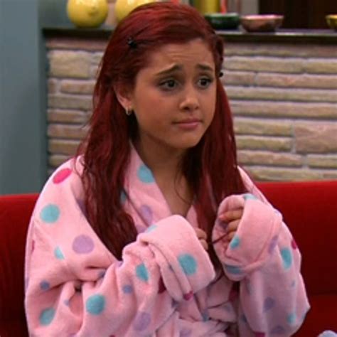 A Woman With Red Hair Wearing A Pink And Blue Polka Dot Robe Sitting On