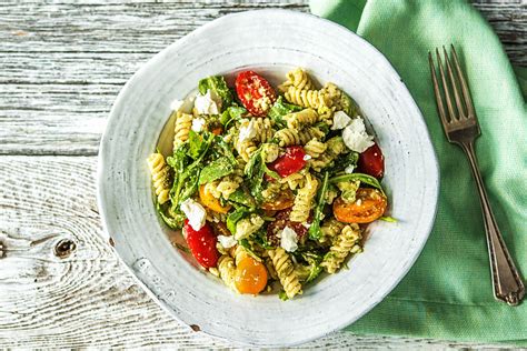 Pastasalade met gekleurde tomaten en feta Met rucola en groene pesto
