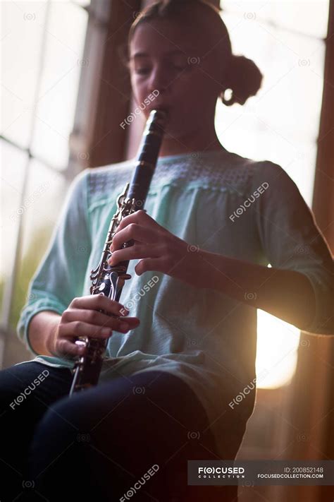 Portrait Of Girl Sitting And Playing On Clarinet — Daylight Learning