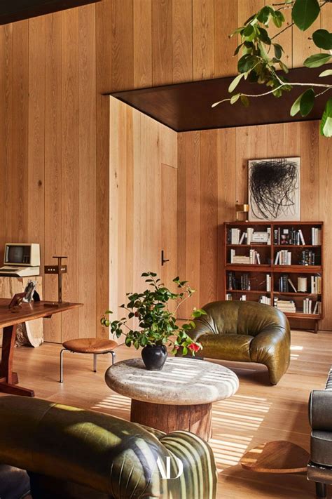 A Living Room With Wood Paneling And Leather Chairs Coffee Table
