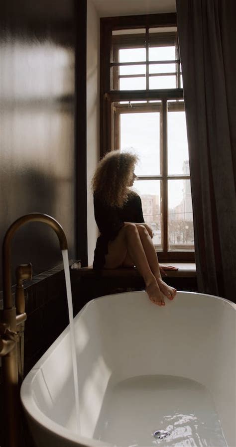 A Woman Doing Her Eyebrow While Sitting On The Ledge Of The Bathroom Window · Free Stock Video