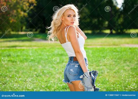 Beautiful Blonde Woman Dressed In A Denim Jacket And Shorts Stock Image Image Of Back