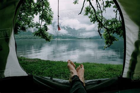 Feet On Man Laying In Camping Tent At Lake Stock Photo Dissolve