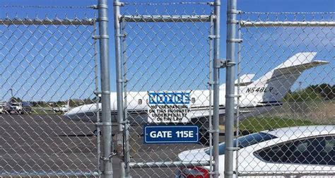 Airport Perimeter Fence With Warning Sign In The Restricted Area