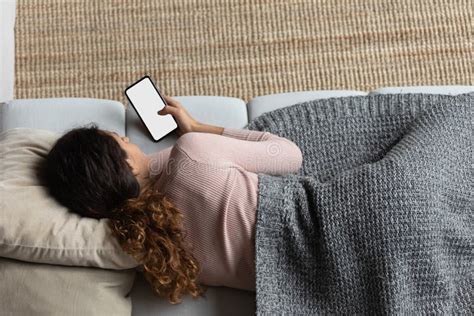 Top View Of Woman Covered With Blanket Relaxing With Smartphone Stock