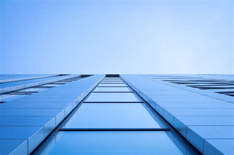 A Low Angle Shot Of A The Windows In A Tall Office Building Blue Sky