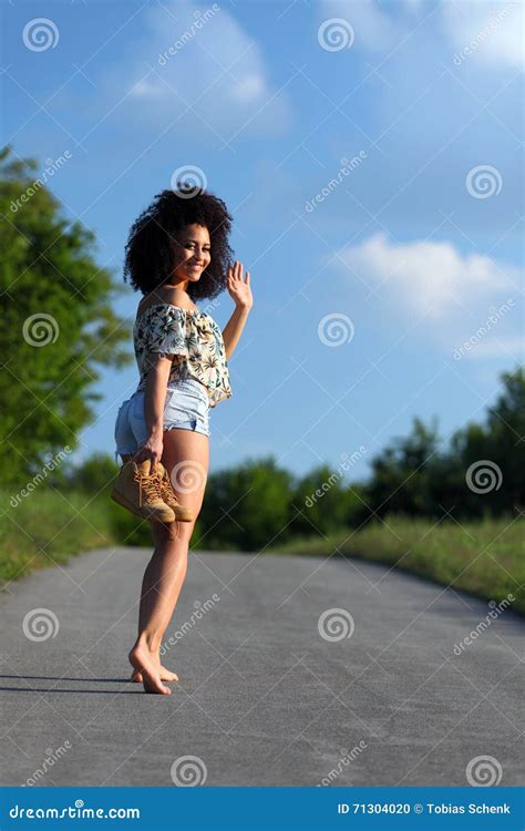 Beautiful African Woman With Curly Hair Barefoot On A Walk In The