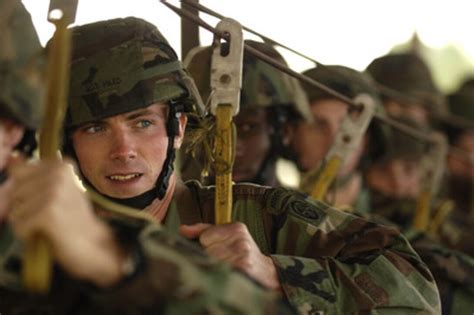 A Us Army Paratrooper Listens To A Jumpmaster Brief Prior To A