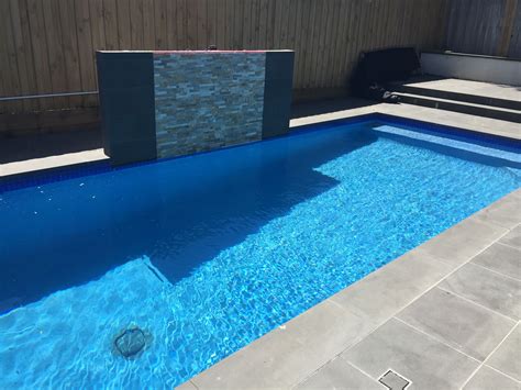 Glass Waterline Tiles Pool With Royal Blue Rendered Interior Complemented By A Bluestone And