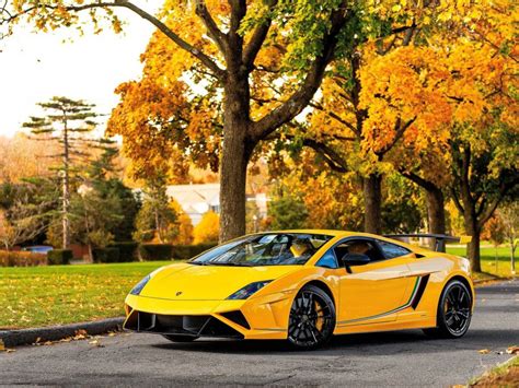 A Yellow Sports Car Is Parked On The Side Of The Road In Front Of Some