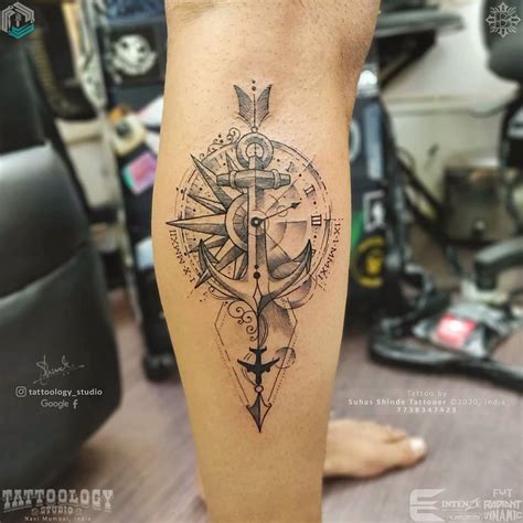 A Mans Leg With A Compass Tattoo On It And An Anchor In The Middle