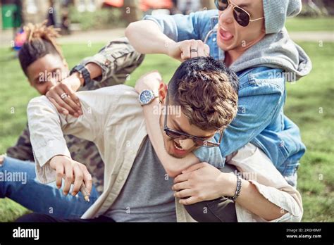Teenage Boys Play Fighting In Park Stock Photo Alamy