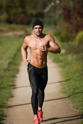 Handsome Strong Muscular Athletic Man Running Outdoors In Nature Stock