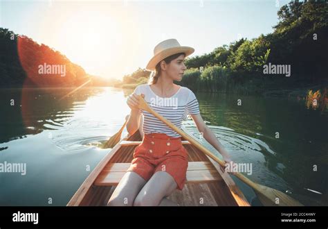 Young Woman Paddling Canoe Couple Enjoy Boat Ride On The Summer Sunset