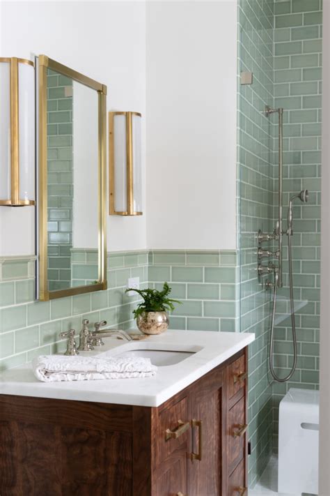 A Bathroom With Green Tiled Walls And White Counter Tops Gold Framed