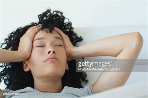 Young Woman Holding Her Head Eyes Closed Photo Getty Images