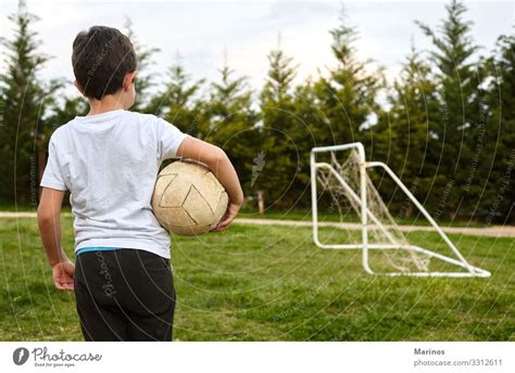 Kid Holding A Soccer Ball On Garden Field A Royalty Free Stock Photo