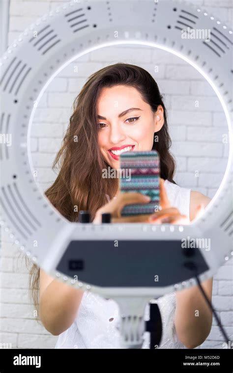 Young And Beautiful Woman Taking Selfie Picture With Mobile Phone In Light Of The Ring Lamp