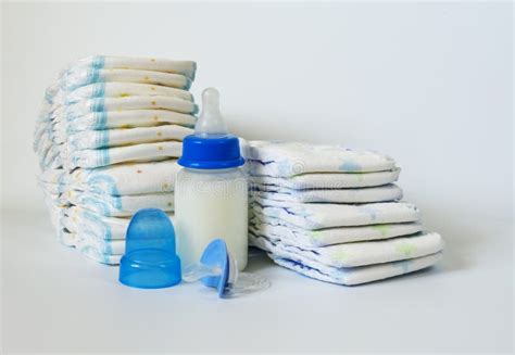 Stack Of Baby Disposable Diapers Pacifier And Electronic Thermometers