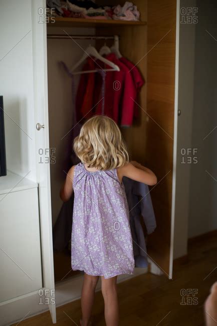 Rear View Of Girl Removing Clothes From Wardrobe Stock Photo Offset