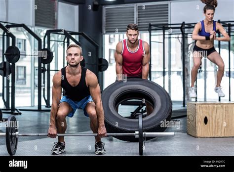 Three Muscular Athletes Lifting And Jumping Stock Photo Alamy