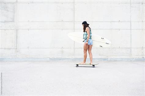 Barefoot Girl On Skate Carrying Surfboard By Guille Faingold