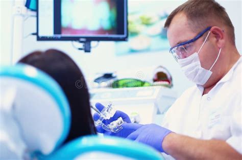 Retrato De Um Dentista Que Trata Os Dentes De Uma Jovem Paciente Foto