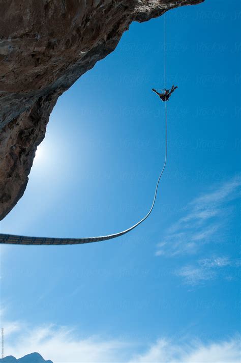 A Climber Ascends A Rope On A Cliff Face Del Colaborador De Stocksy