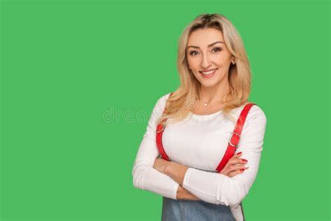 Portrait Of Positive Self Assured Beautiful Adult Woman In Stylish Overalls Holding Arms Crossed