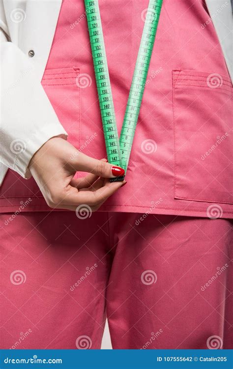 Close Up Of Female Doctor Standing Measuring Herself With Tape Stock